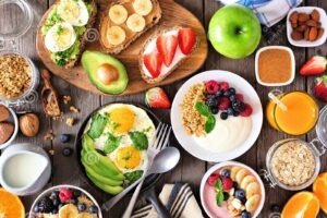 healthy breakfast table scene fruit yogurts smoothie bowl oatmeal nutritious toasts egg skillet above view over wood 170649623 1